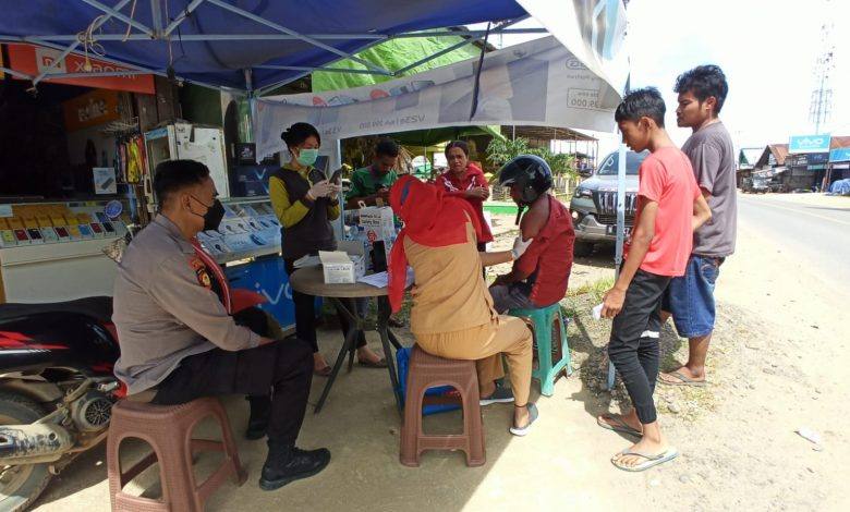 Kapolsek Kongbeng Mengawal Pelaksanaan Vaksinasi Jemput Bola di Pasar